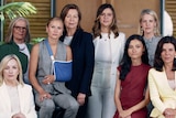 Group of women stand with serious faces