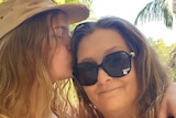 Bo Duincan kisses and hugs her mother Deb Duncan on the side of her face.