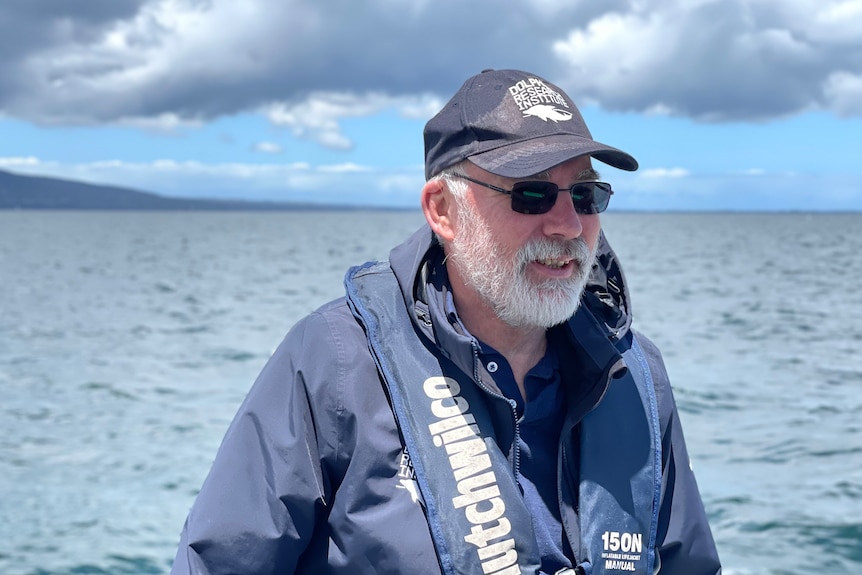 An older man on a boat on the ocean.