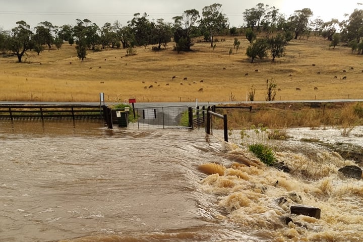 A flooded driveway at a rural property. 