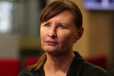 A woman with a black shirt and hair in a ponytail.