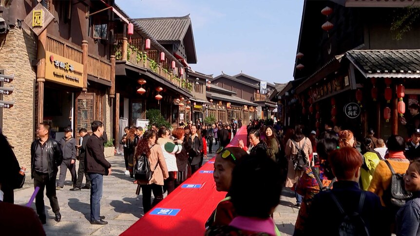 a long red table is shown along a strip of chinese buildings