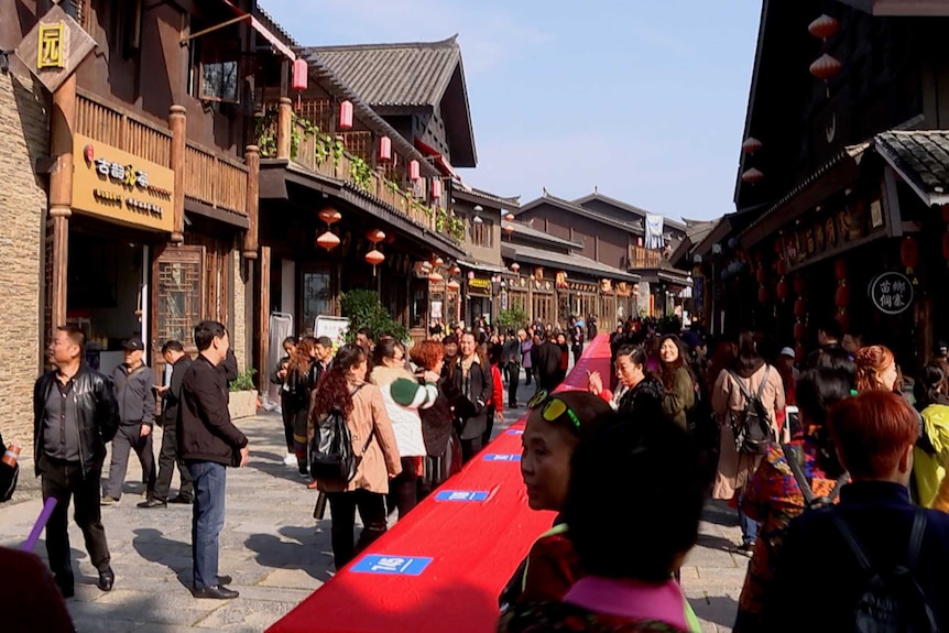 a long red table is shown along a strip of chinese buildings