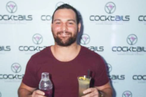 Reece Clarke holds a drink at an event, date and location unknown