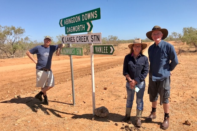 Pip Courtney and crew standing next to signs for Abingdon Downs and Dagworth on outback road in Gulf Country.