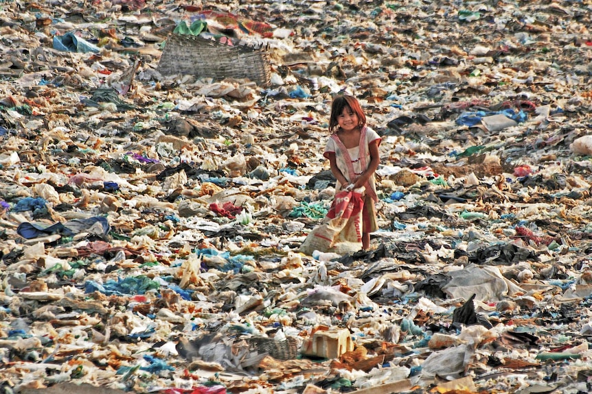 Young girl smiles at a Cambodian rubbish dump