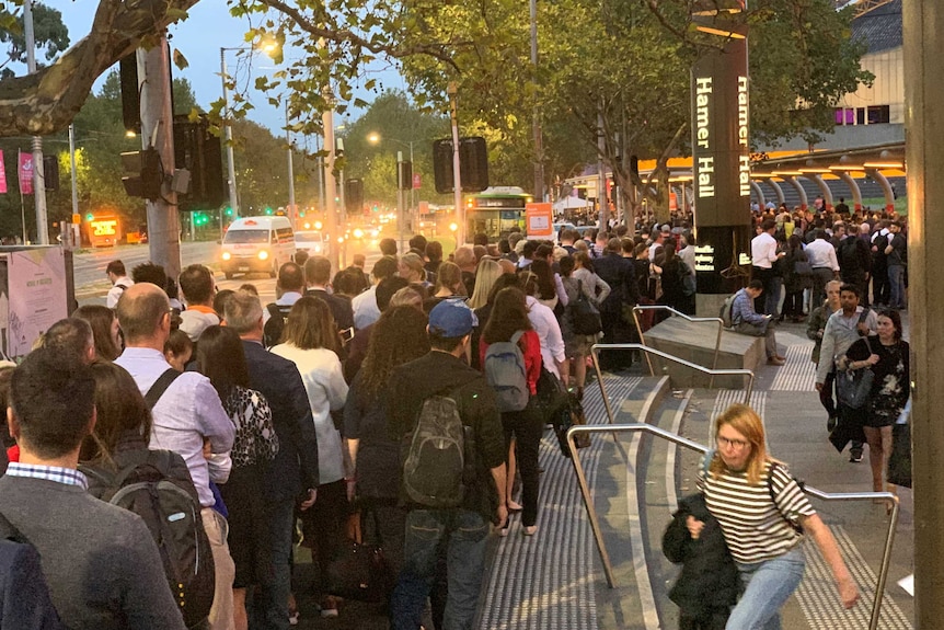 Passengers queue for replacement buses near the Arts Centre in Melbourne.