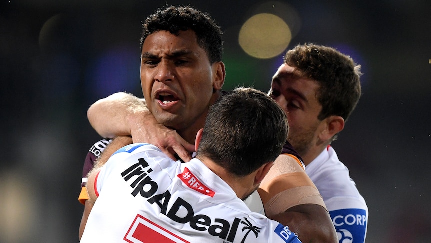 A Brisbane Broncos NRL player stands in a tackle against the St George Illawarra Dragons.