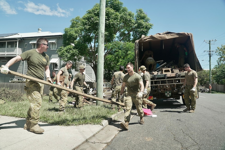 ADF personnel help clean up flood-ravaged street in Brisbane