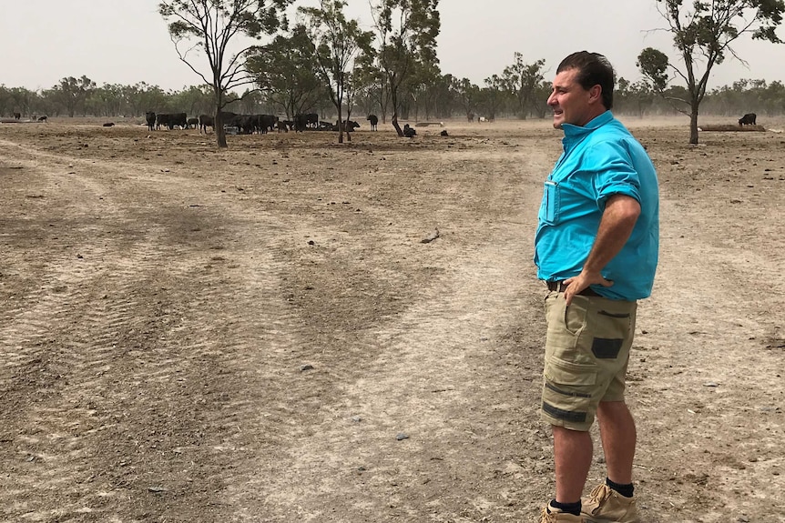 James Moore stands on dry, dusty, brown dirt.