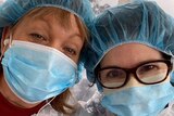 Two nurses wearing PPE wearing masks