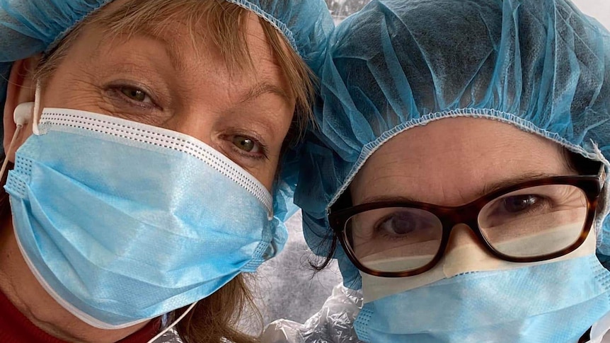 Two nurses wearing PPE wearing masks