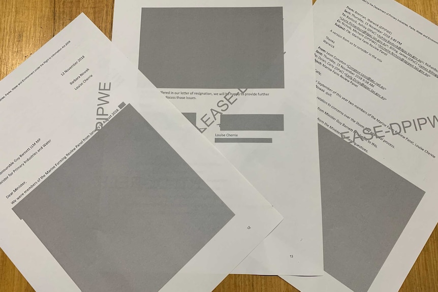 Three pieces of paper largely covered by black boxes.