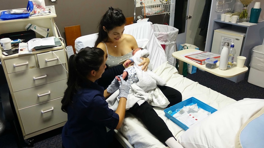 Lauren on a hospital bed, holding baby Lavendi.