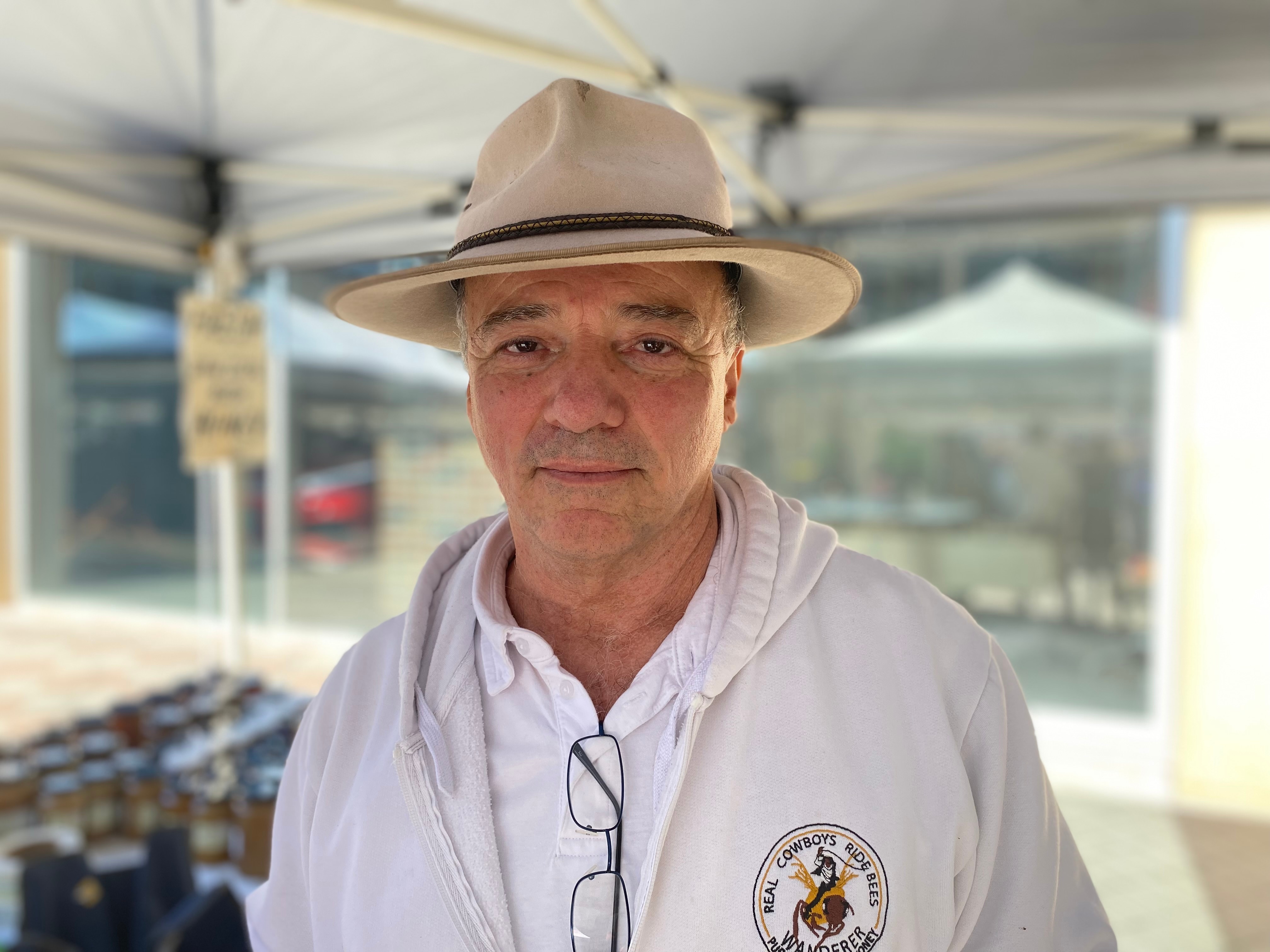 Man wearing a hat looks at camera