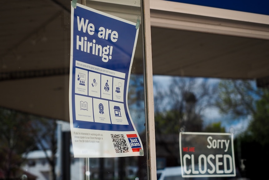 Signs saying we are hiring and closed in a shopfront in Griffith