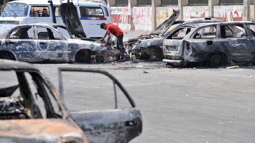 An Egyptian man inspects burnt out cars near Cairo University.