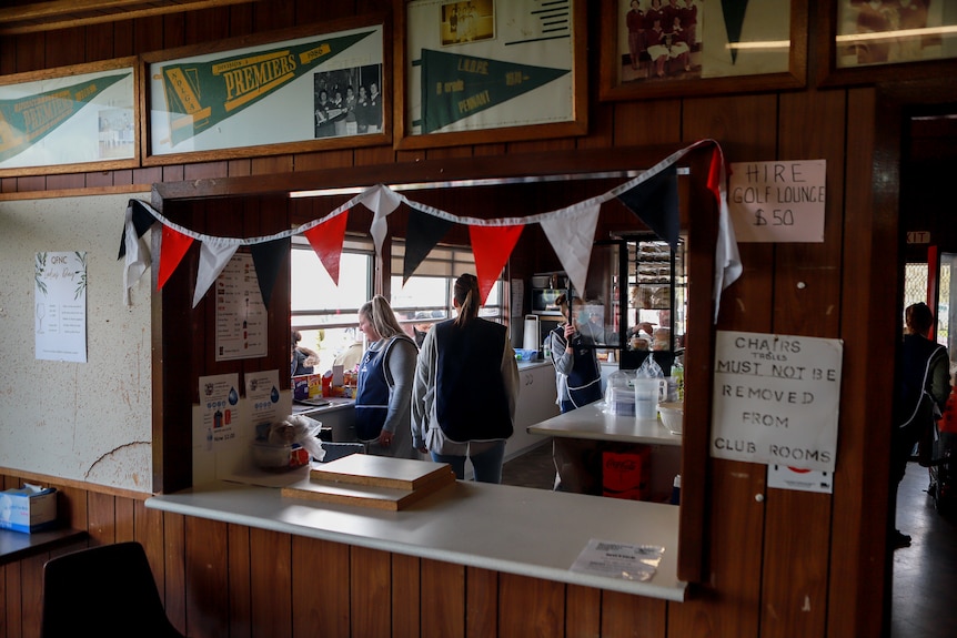 Women in canteen kitchen serving customers through window