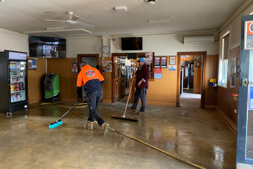 people wearing yellow emergency uniform clean up a flooded commercial kitchen