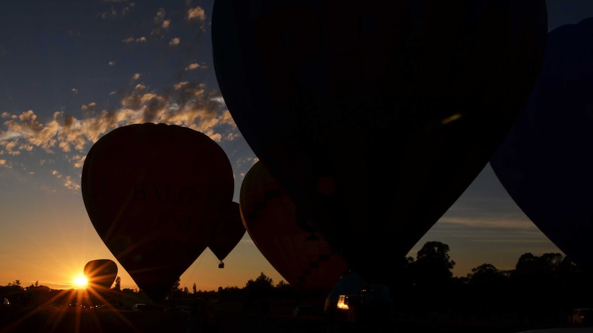 Hot air balloons prepare to launch in the early hours of the morning.