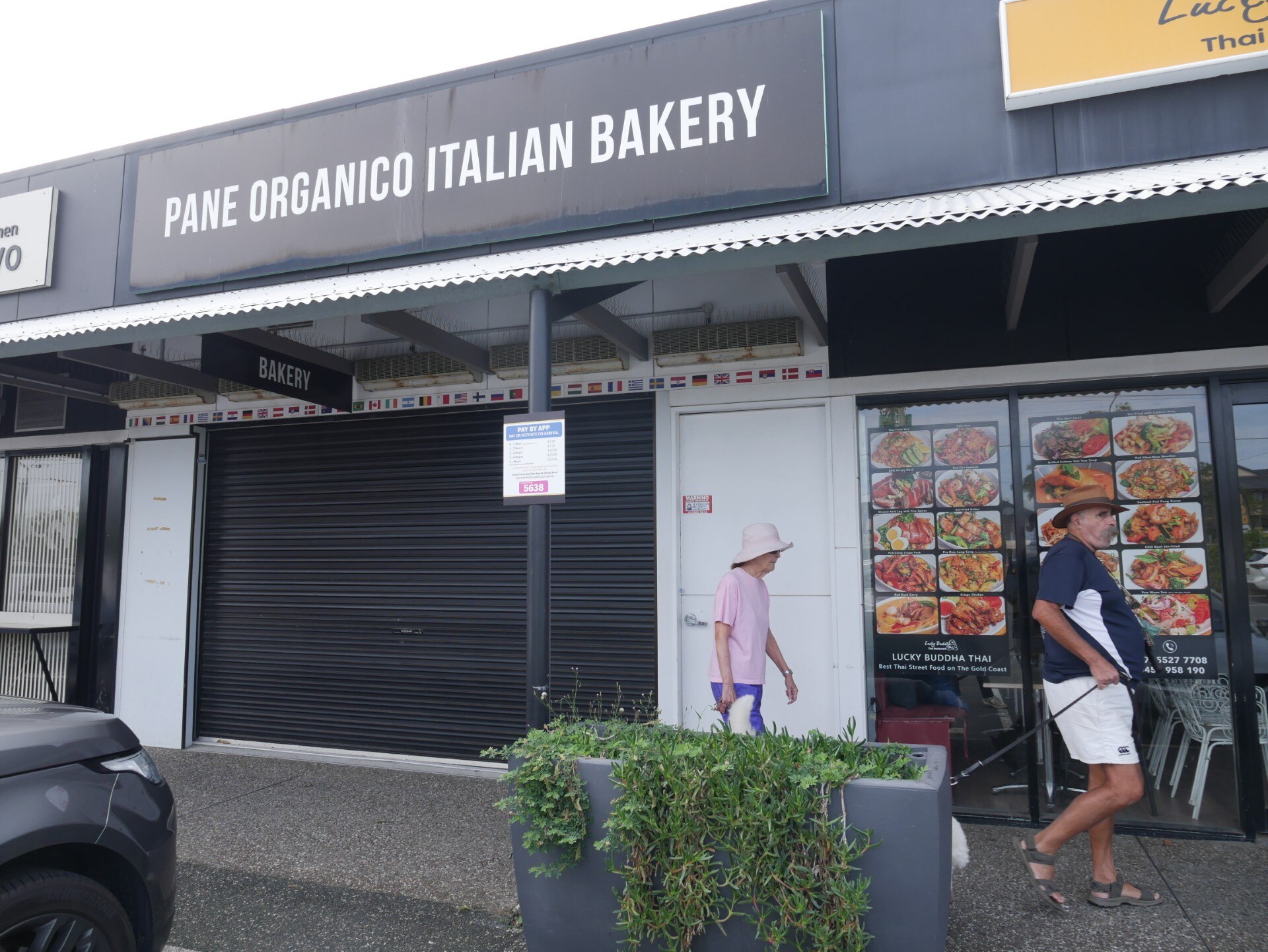 front of pane organico bakery with two people walking past in front