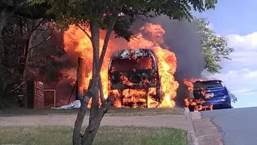 Fire engulfs a maxi taxi parked in a Brisbane street