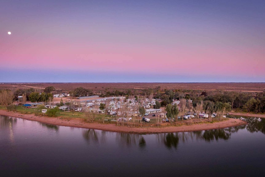 Arial shot of a caravan park on a lake at sun set.