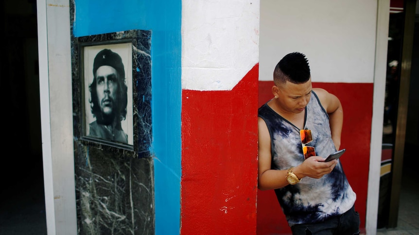 A young Cuban checks his phone at an internet hotspot.