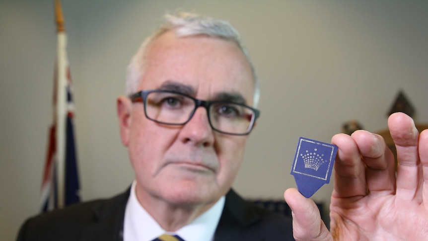 Andrew Wilkie holding a pick with the Crown Casino logo