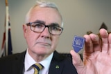 Andrew Wilkie holding a pick with the Crown Casino logo