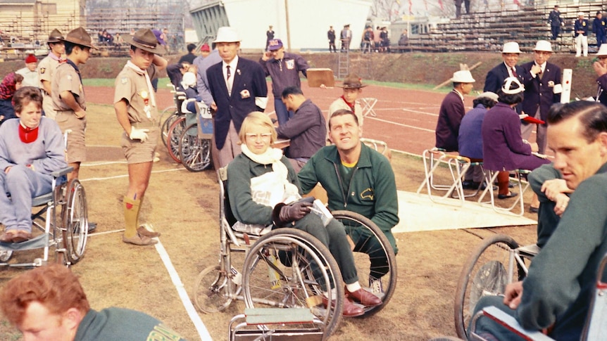 Elizabeth Edmondson surrounded by athletes and officials at the 1964 Tokyo Paralympics.