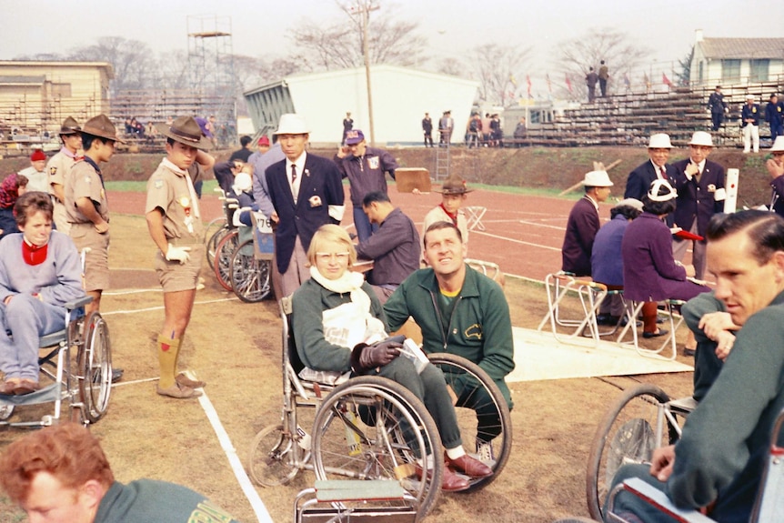 Elizabeth Edmondson surrounded by athletes and officials at the 1964 Tokyo Paralympics.