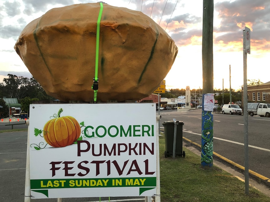 roadside sign that reads 'Goomeri Pumpkin Festival - last Sunday in May' next to a big orange pumpkin sculpture