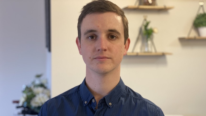 A profile shot of a man standing inside his house