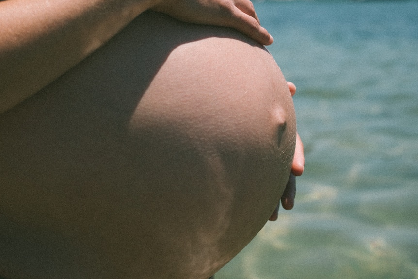 A close-up image of a woman's baby bump