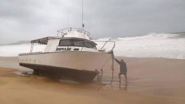 Fishing boat stranded on beach by NSW storms