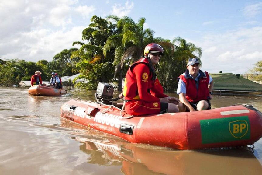 Rescue team rides an inflatable boat down a flooded street in Ipswich, west of Brisbane on January 13, 2011.