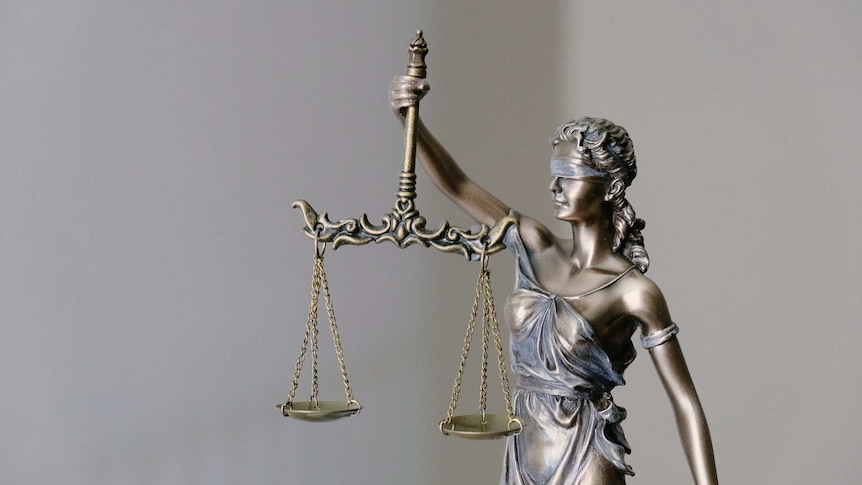 A statue of a woman holding up the scales of justice