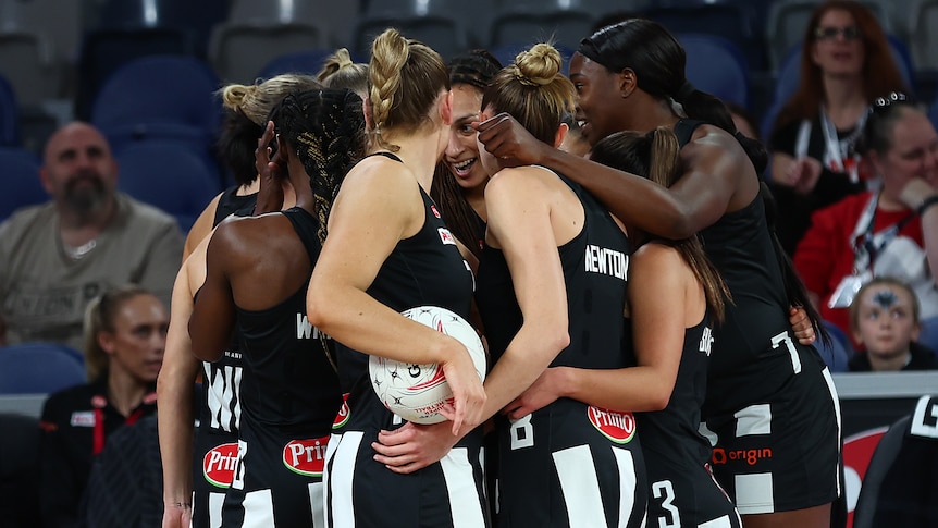 Collingwood Magpies players huddle together during a Super Netball game.