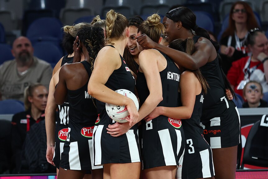 Collingwood Magpies players huddle together during a Super Netball game.