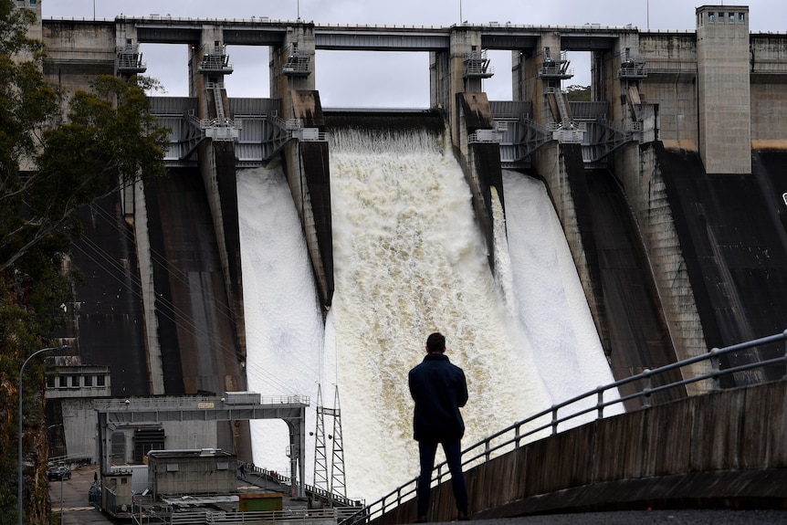 A person watches on as the Warragamba Dam spillway is seen outflowing in november 27 2021