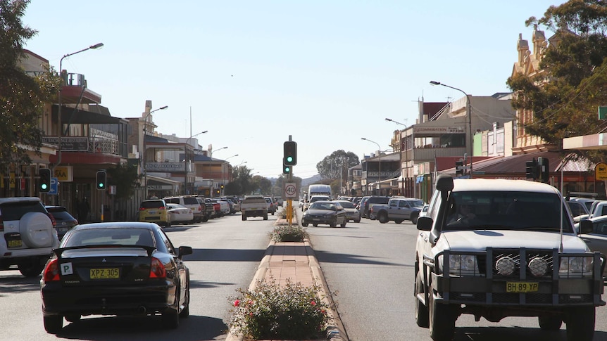 Looking east down Argent Street in Broken Hill from the median strip showing traffic.