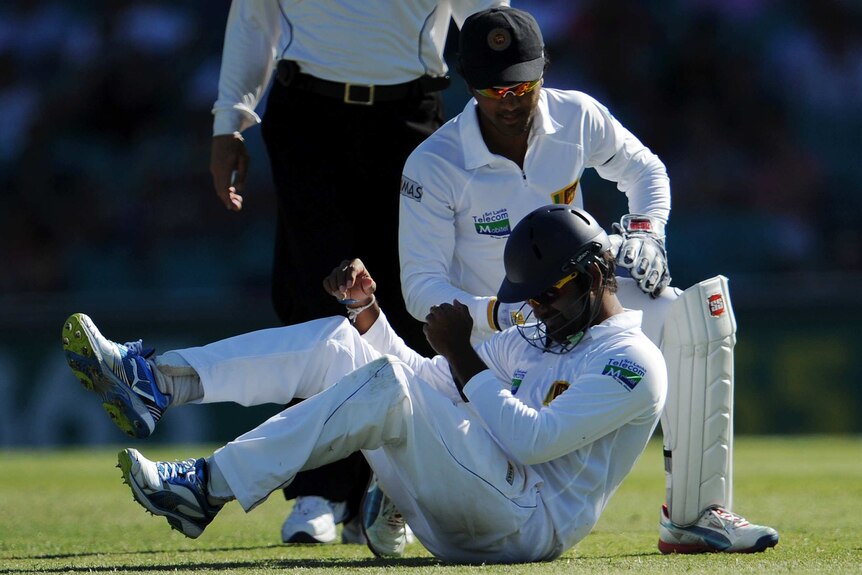 Lahiru Thirimanne winces after copping the full brunt of Matthew Wade's sweep shot at silly mid-on.