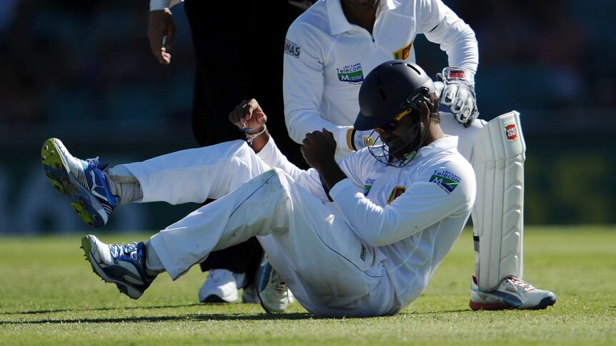 Lahiru Thirimanne winces after copping the full brunt of Matthew Wade's sweep shot at silly mid-on.