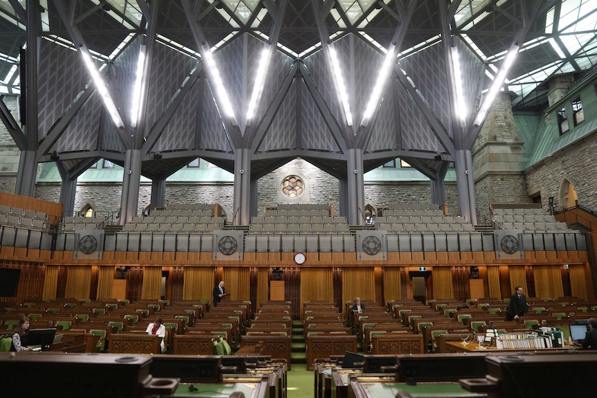 Canada's house of commons, with rows of green and wood benches.