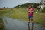 A woman in gumboots standing in a flooded field