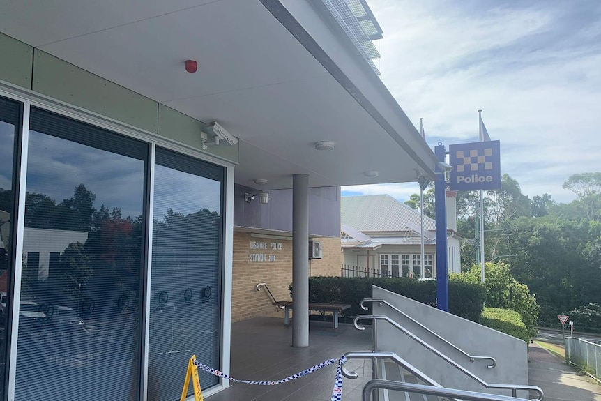 An exterior of Lismore Police Station with crime-scene tape in the foreground.