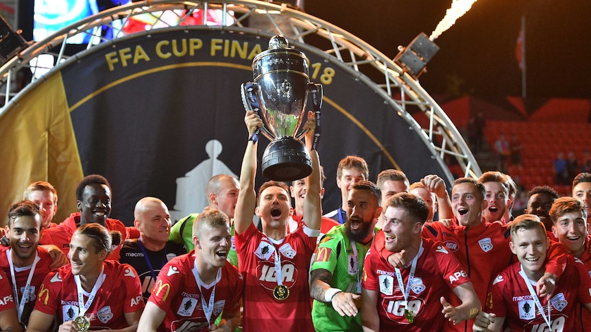 Adelaide United players celebrate with FFA Cup trophy