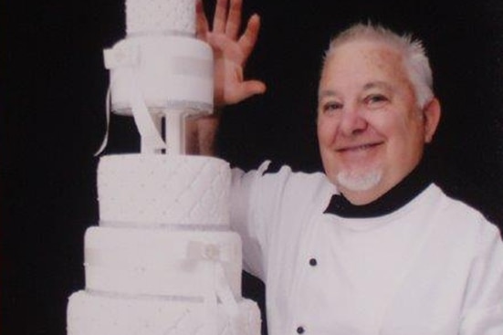 Farmer, Greg Smith standing next to a tiered wedding cake
