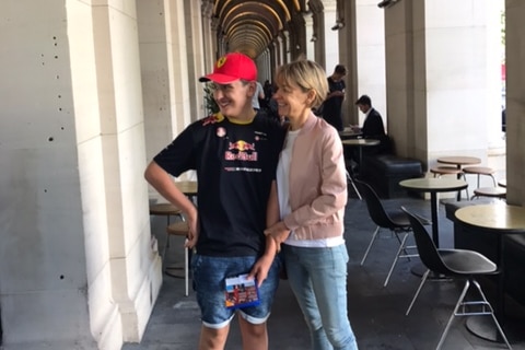 Kerry Moore and her son Oliver stand outside undercover in a sandstone arched walkway